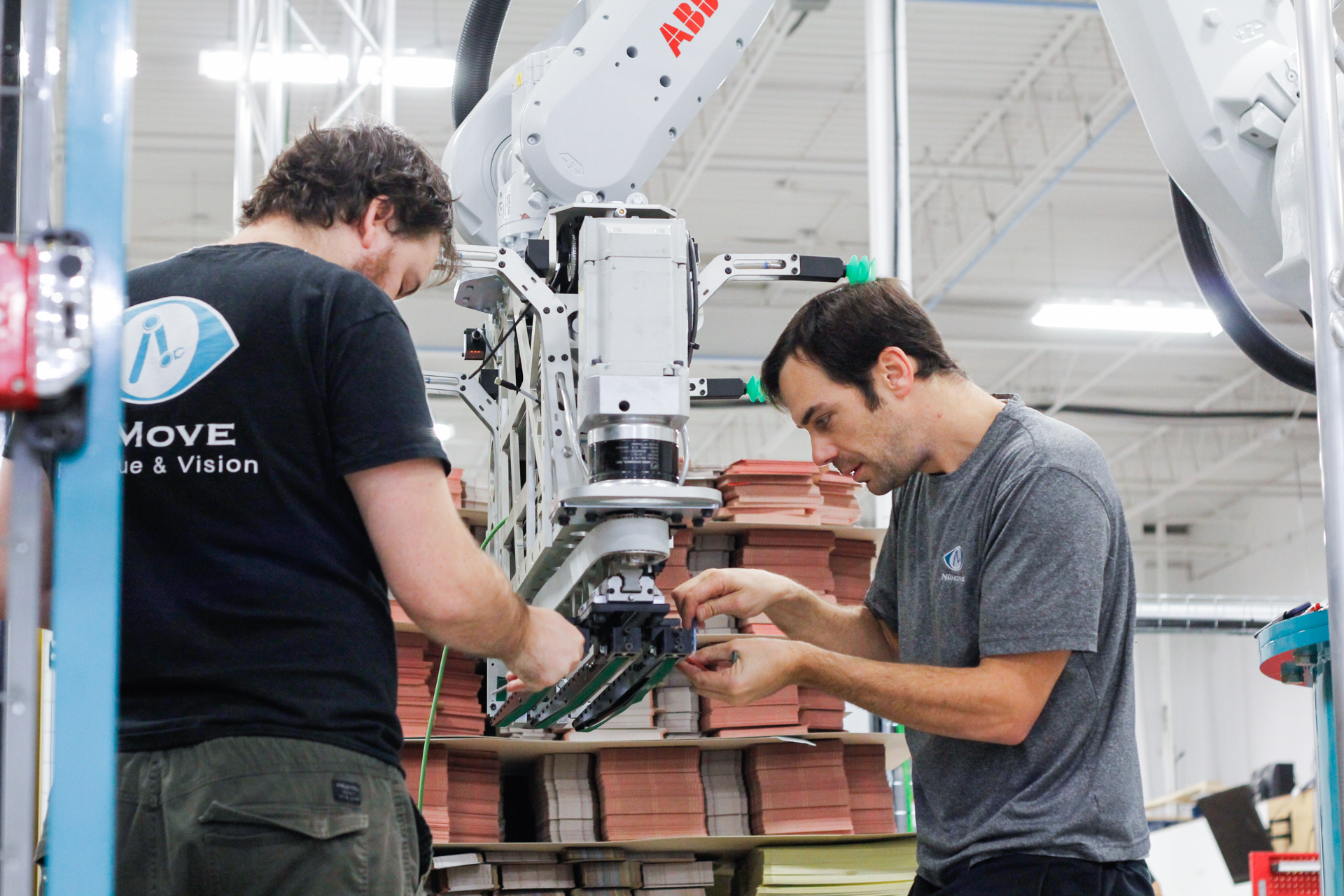 NūMove employees adjust a robot-tool
