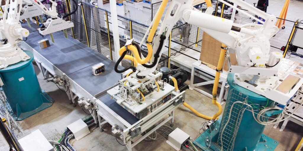Two robots prepare palletizing patterns while one robot handles layer palletizing.